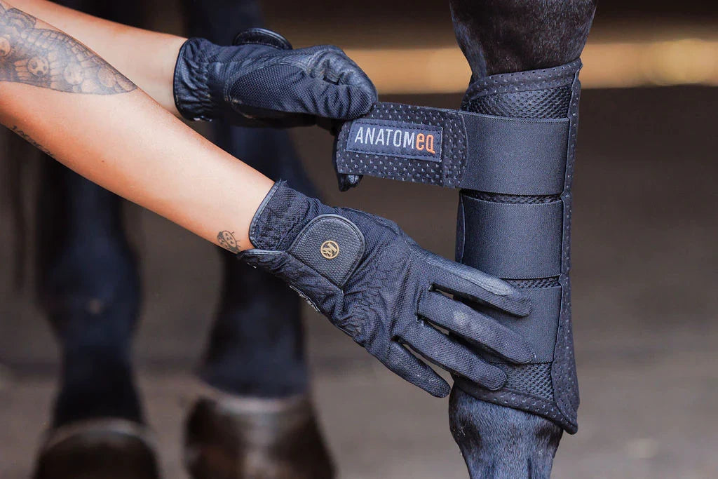 Anatomeq AirGuard Brush Boots in black polo wrap style with padded interior and adjustable straps for horse leg protection.