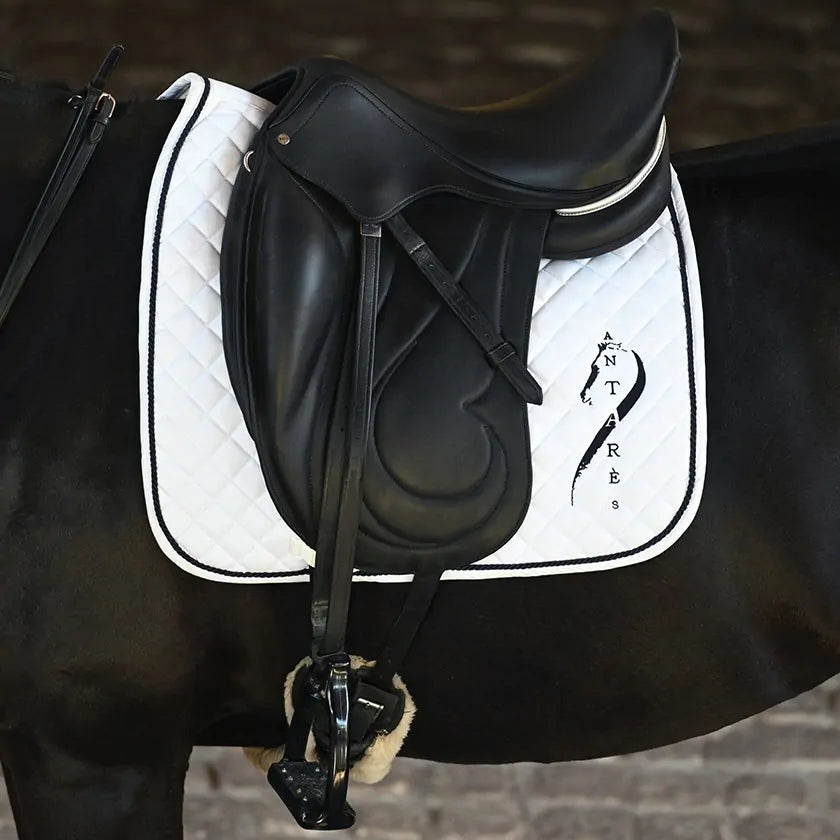 White Antares dressage saddle pad with quilted design and logo, designed for horse riding and saddle comfort.